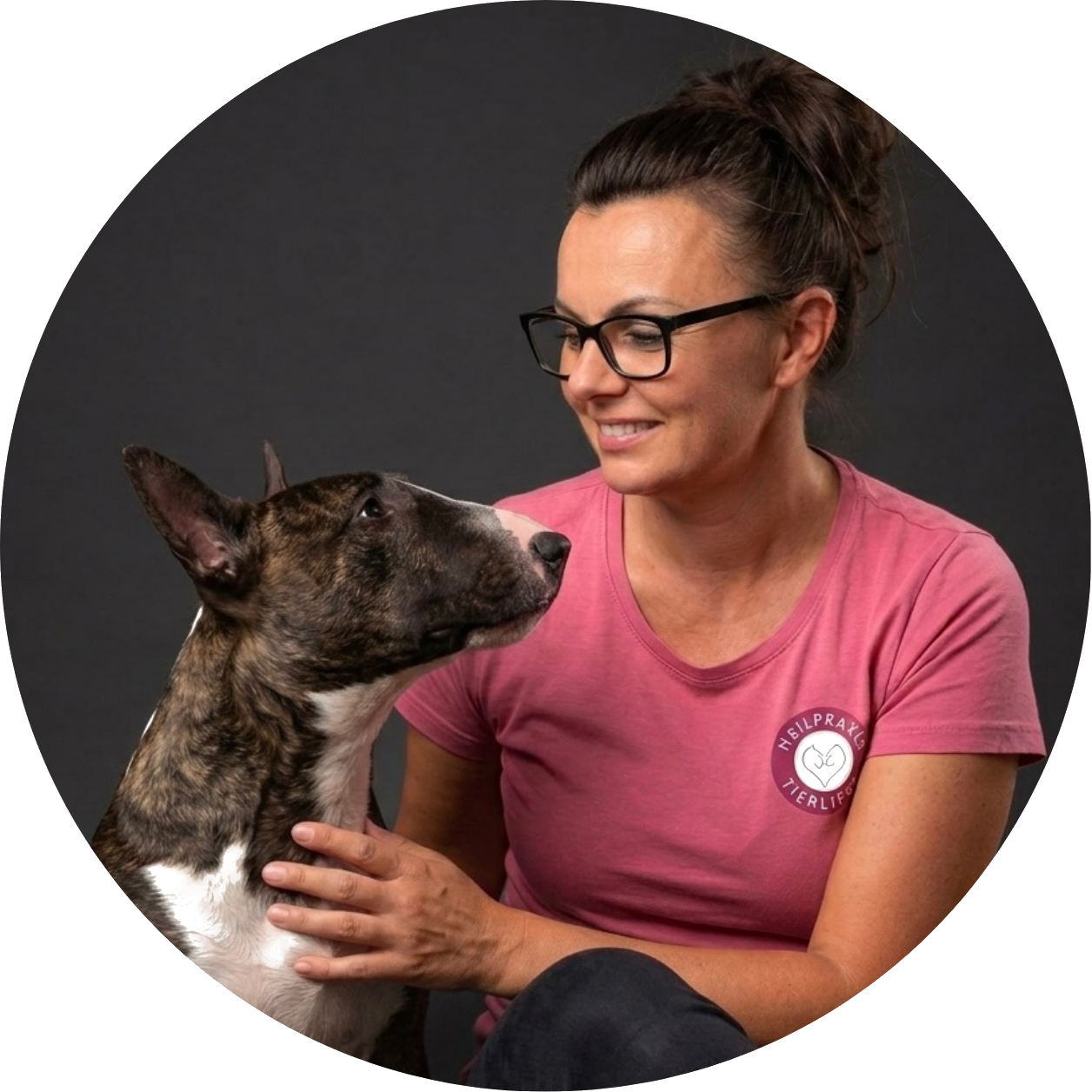 Anna und Bullterrier Elli schauen sich – Symbol für die Ursachenforschung bei chronischen Beschwerden im Tierliebe Intensivprogramm.